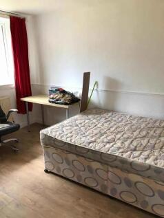 A simple and functional bedroom featuring a sin...