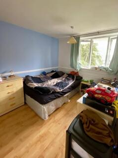 A cozy double bedroom featuring a large window ...