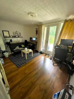 A cozy living room with polished wooden floors,...
