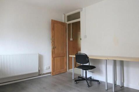 A simple communal workspace featuring a long de...