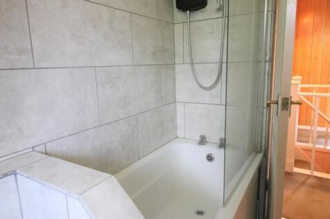 Bright and clean bathroom suite featuring a mod...