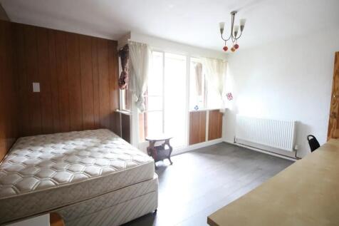 A bright double bedroom featuring a large windo...