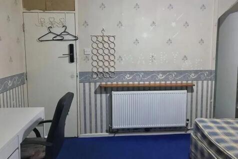 A compact room featuring a simple desk and chai...