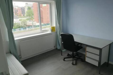 A bright, tidy single bedroom with a large wind...