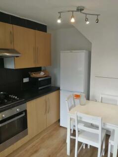 A neat and functional kitchen featuring light w...