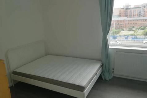 A neat double bedroom featuring a white metal b...