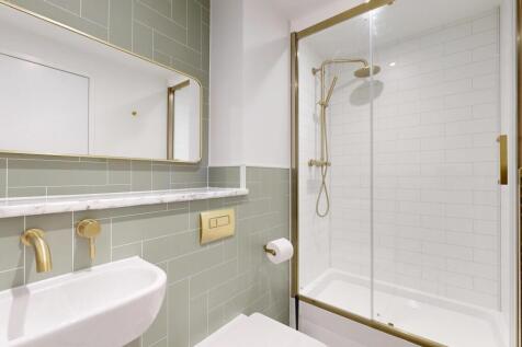 Bright, modern bathroom with a clear glass show...