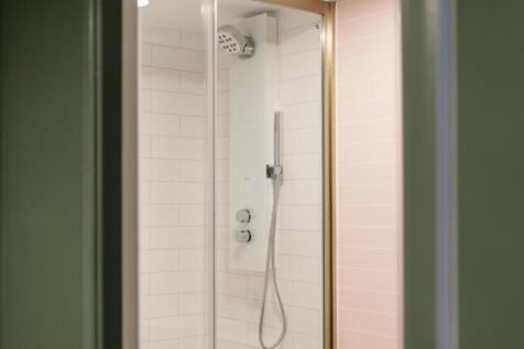 A modern, clean bathroom with a spacious shower...