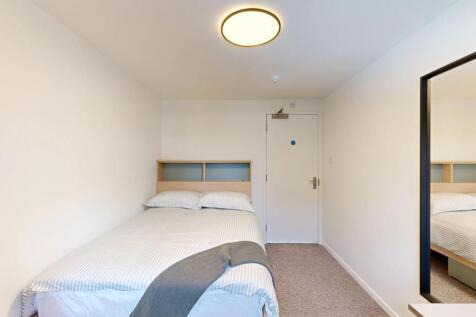 Bright, simply styled bedroom with a comfortabl...