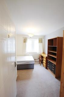 Bright, neutrally decorated bedroom with a doub...