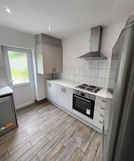 Bright and modern kitchen with sleek white cabi...