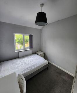 A clean and bright double bedroom featuring a w...