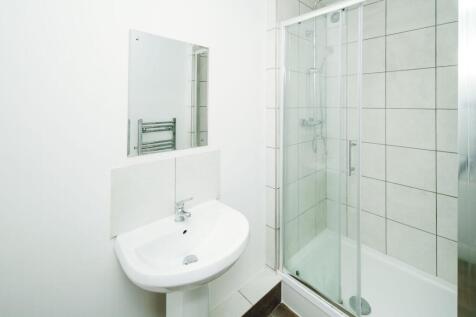 Bright, modern bathroom with a tiled shower enc...