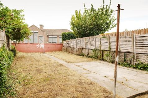 Private rear garden with a long lawn, paved are...
