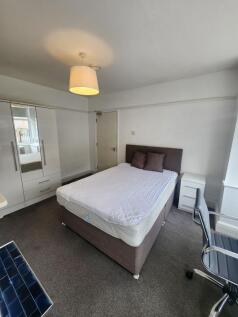 A well-lit, tidy double bedroom featuring a com...