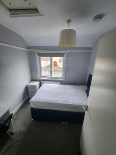 A bright and tidy bedroom featuring a large win...