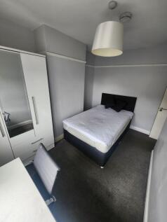 A well-maintained, cozy bedroom featuring a bed...