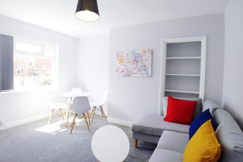 Bright, modern living room with a comfy grey so...