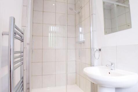 Bright modern bathroom with large tiled walk-in...