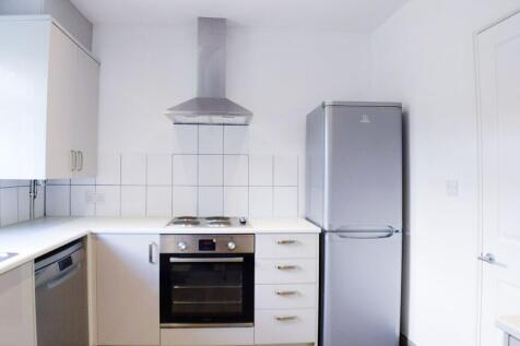 Bright modern kitchen with white cabinets, tile...