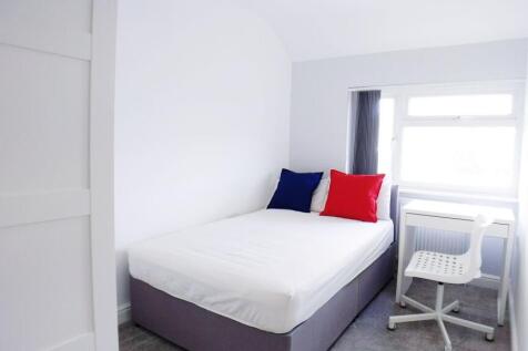 Bright, freshly painted bedroom with a comforta...