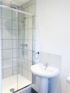 Bright, modern bathroom featuring a tiled walk-...