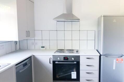 Bright, modern kitchen with white cabinets, ele...