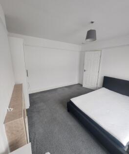 Bright and tidy bedroom featuring a large bed w...