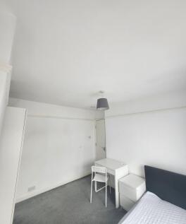 A clean and minimalist bedroom with white walls...