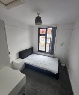 A bright, neatly maintained bedroom with a sing...