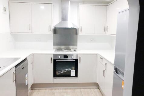 Bright modern galley-style kitchen with white c...