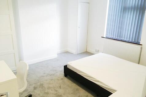 Bright, neutral double bedroom with a simple be...