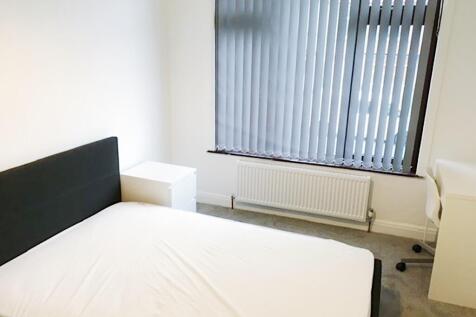 Bright, simply furnished bedroom with a double ...