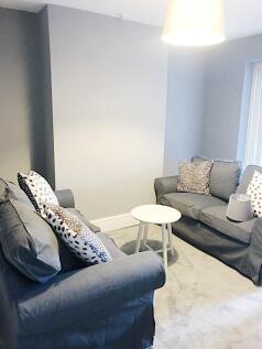 Bright, neutral living area with two comfortabl...