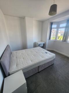 A bright, well-maintained double bedroom with a...