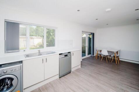 Bright, modern kitchen-dining space with white ...