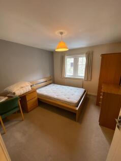 A cozy student bedroom featuring a double bed w...