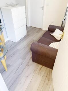 Bright, modern lounge area with pale wood-effec...