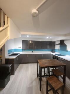 Modern kitchen featuring sleek dark cabinets, a...