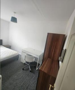 A neat and functional single bedroom featuring ...