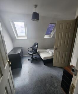 A cozy single bedroom featuring two skylight wi...