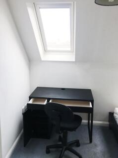 Compact bedroom with a skylight over a neat bla...