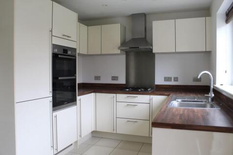 Modern, well-maintained kitchen with white cabi...