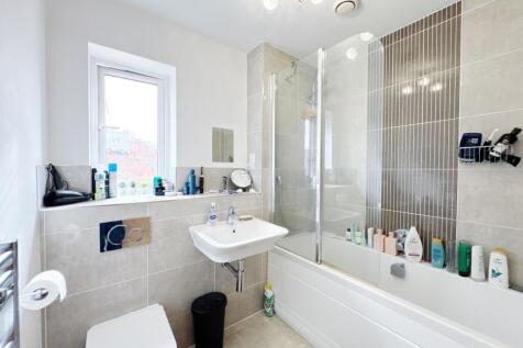 Bright and modern bathroom featuring a bathtub ...