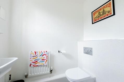 Bright, modern bathroom with a wall-hung toilet...