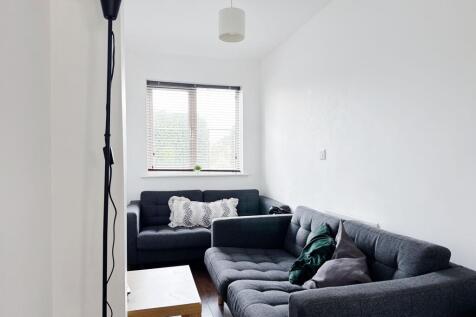 Bright, modern living room with two matching gr...