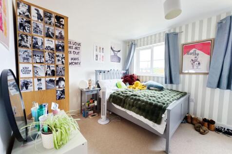 Bright, neatly styled double bedroom with a com...