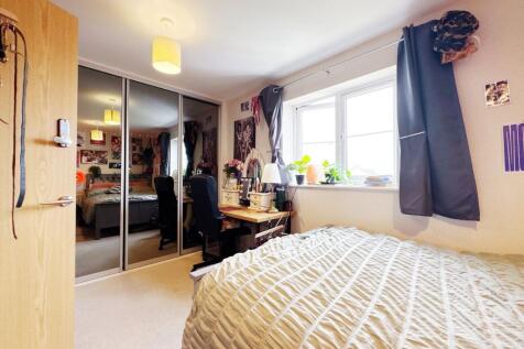 Bright, well-furnished bedroom with a large win...