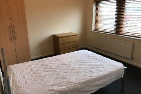 A tidy and well-lit bedroom featuring a single ...