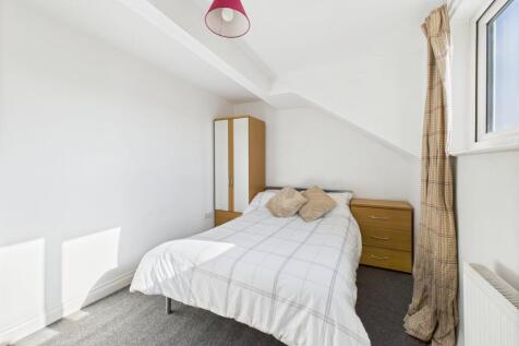 A well-lit, tidy double bedroom featuring a com...